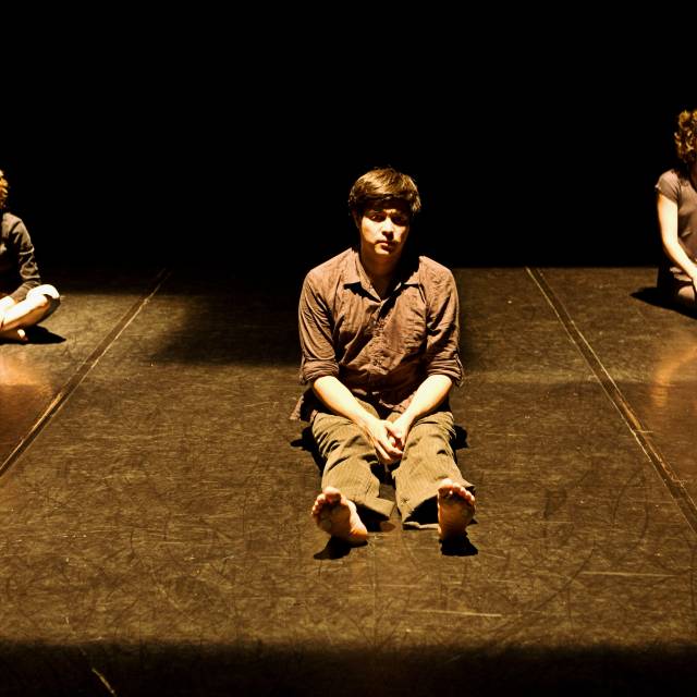 three figures sit staring out into the space